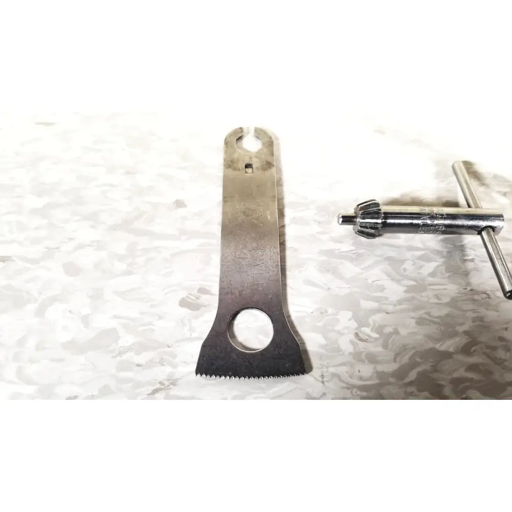 Silver metal bicycle chain tool with serrated edge and circular cutouts in 3m maxi driver ii autoclave tray air set