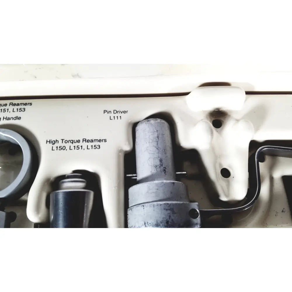 Gray metallic pin driver model l111 placed in white plastic tool tray of 3M driver ii autoclave tray air powered set