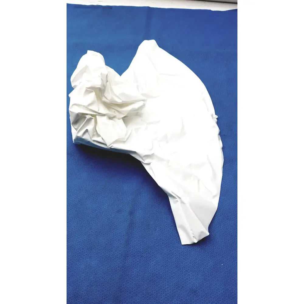 A crumpled white paper bag on a blue surface beside a 3m s-533s high durability hood with integrated head suspension
