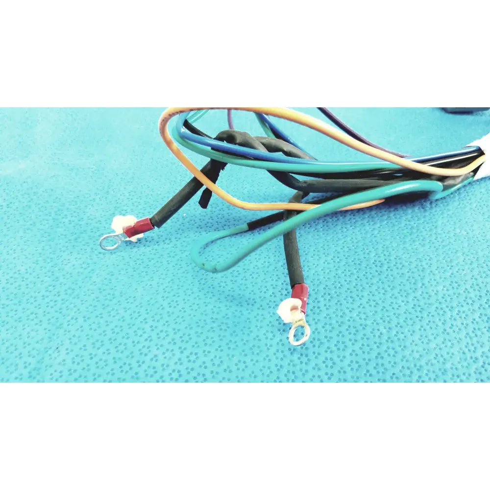A bundle of multi-colored insulated connector wire harness cables with red terminals and metal loop ends