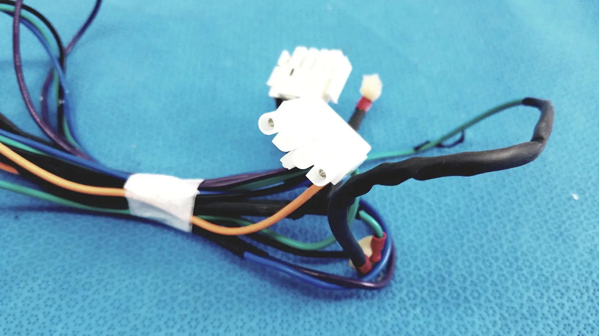 A bundle of multi-colored connector wire harness cables with white plastic connectors and black insulation tied by a white band
