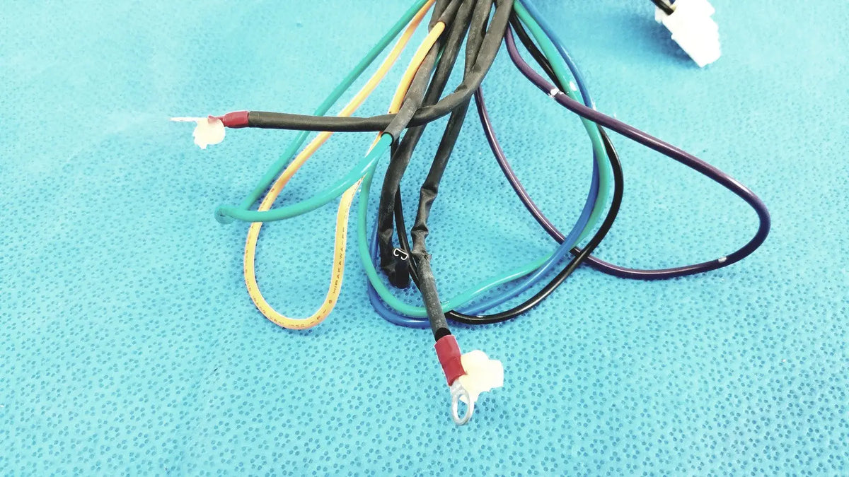 A bundle of multi-colored connector wire harness cables with exposed red and white multi-pin connectors