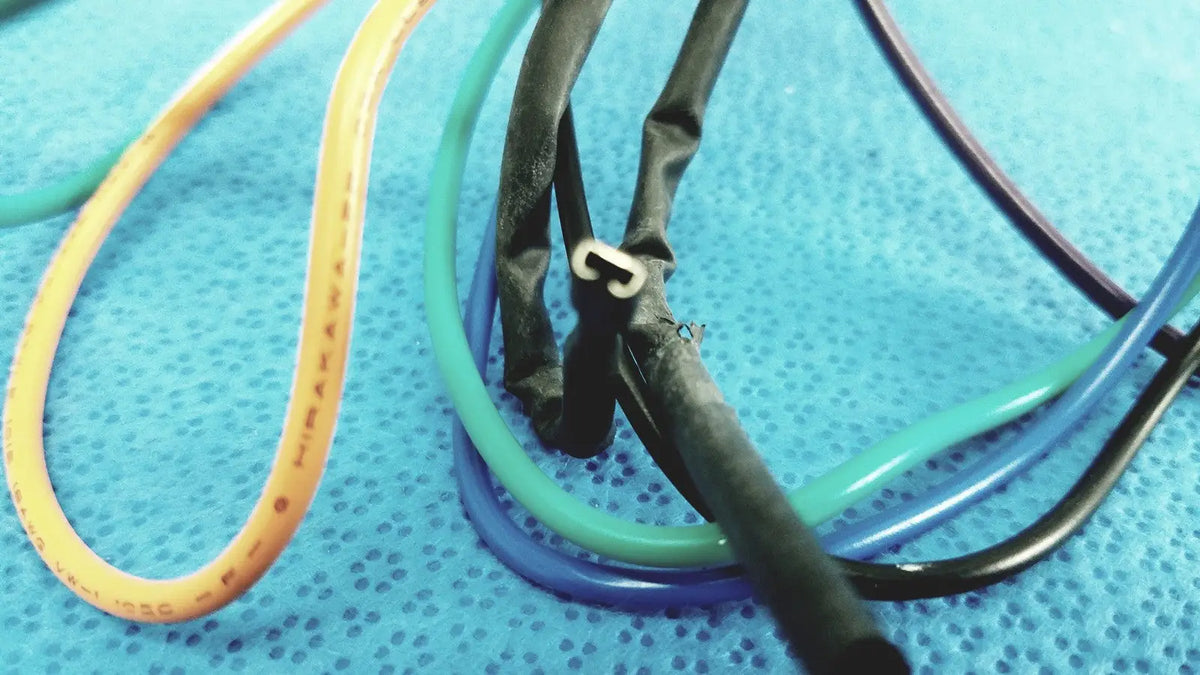 A bundle of colorful yellow green blue and black flexible tubing in 4 multi-pin connector wire harness cables