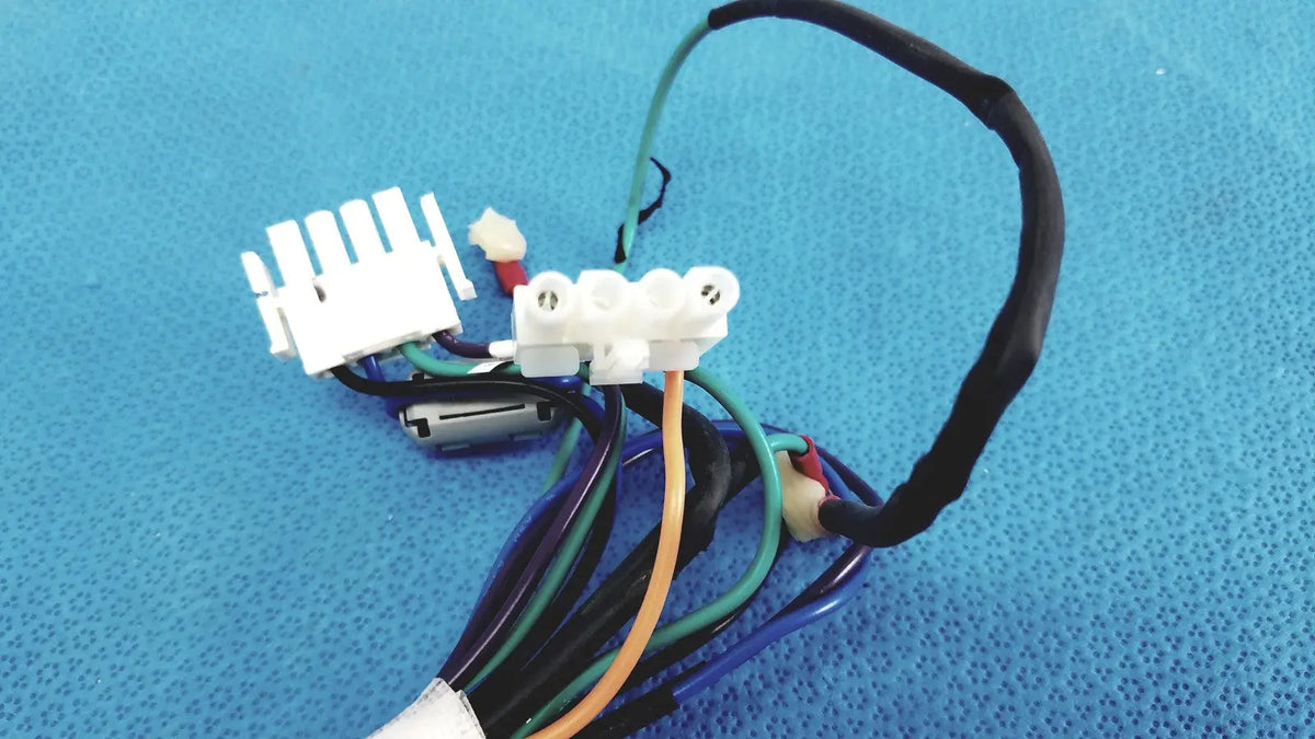 A bundle of multicolored connector wire harness cables with white plastic connectors and a small cylindrical component