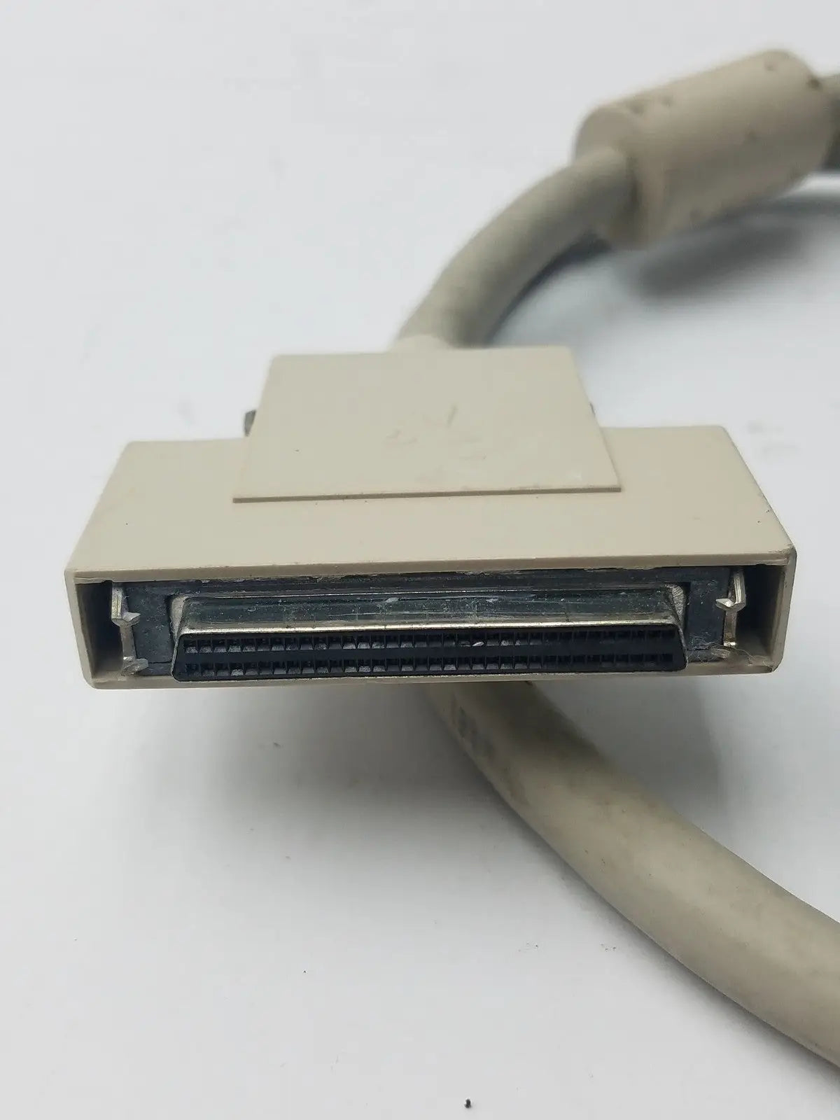 Beige rectangular db-25 male hard drive connector with metallic pins and matching cable for hard drive use