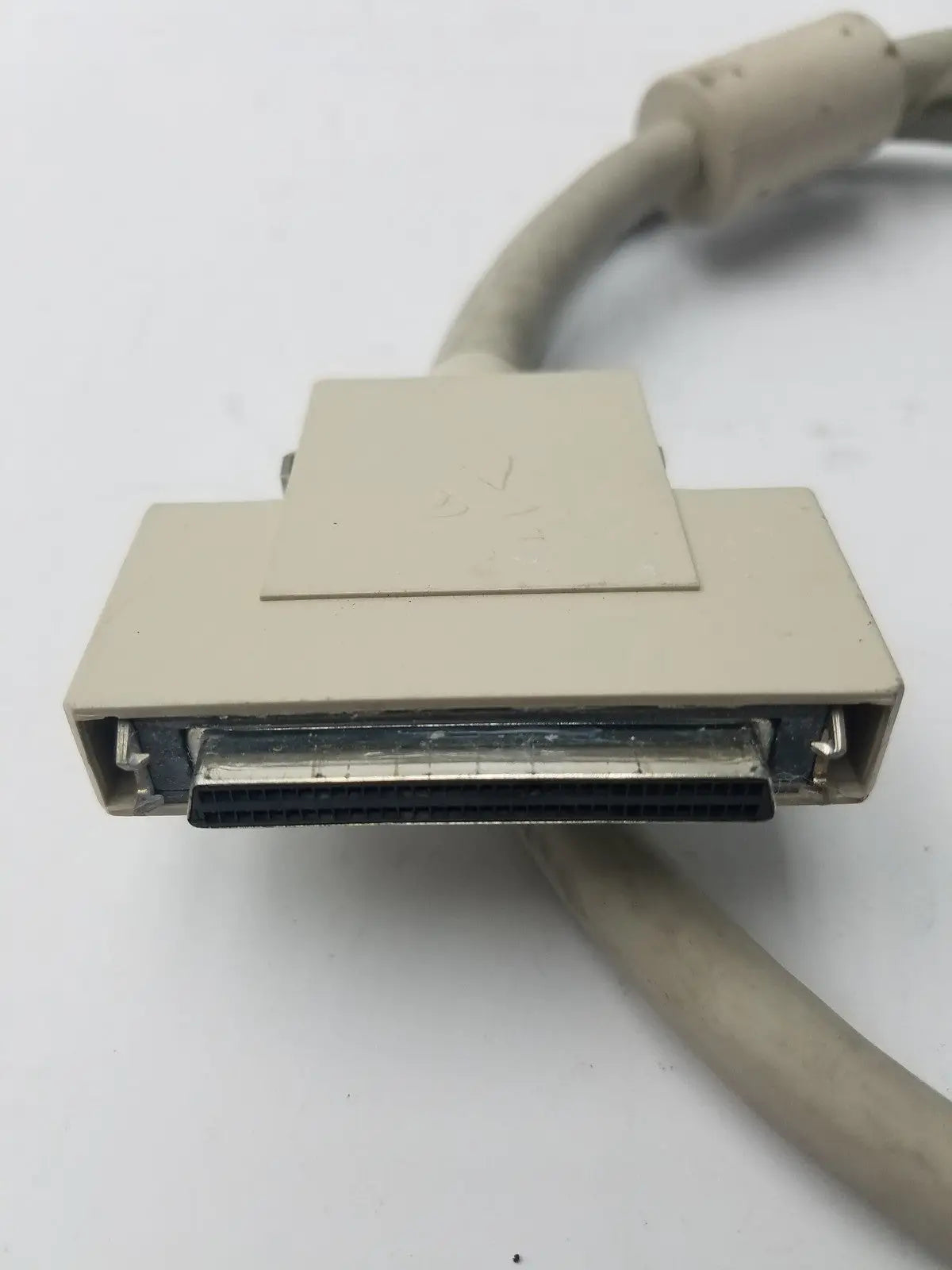 Beige plastic 50-pin male hard drive db-25 connector with metallic contacts and beige cable for scsi-ii connection