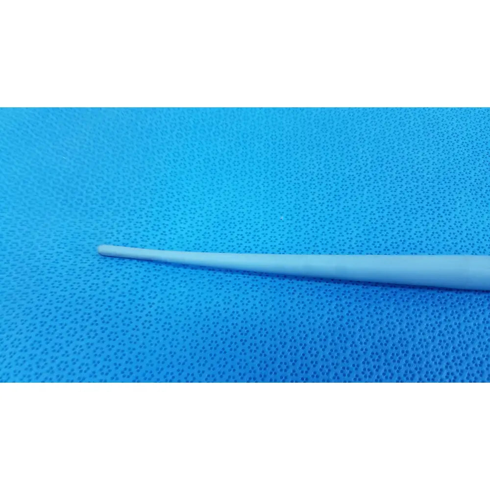 A slender off-white plastic maloney tapered esophageal bougie 42fr with a tungsten-filled tapered tip on a blue surface