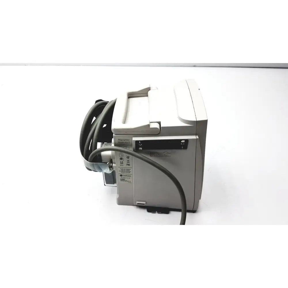 Gray alarms medical monitor with coiled black cable and small screen shown with 60 count medical isolation gown level 2 product