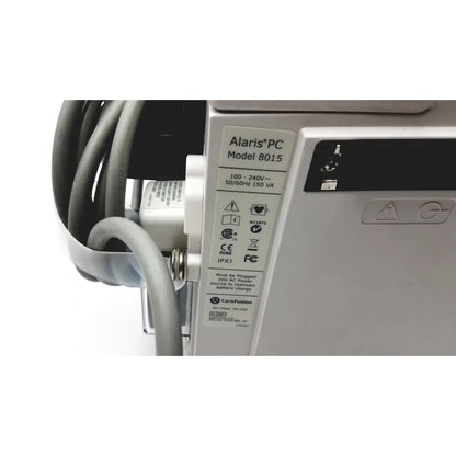 Silver alaris pc model 8015 medical device with labeled specifications shown beside 60 count medical isolation gown level 2