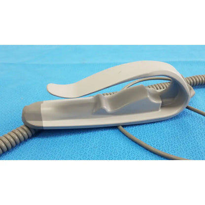 Gray plastic pulse oximeter clip with ergonomic design and coiled cable for remote control of patient lift chair functions