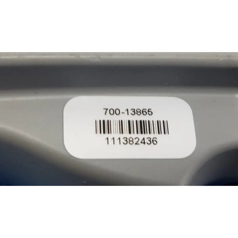 White rectangular label with black barcode on gray plastic surface of remote control for patient lift chair model 700-13865