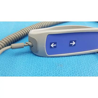 Gray and blue remote control with directional arrows on coiled cord for patient lift chair 700-13865 functions