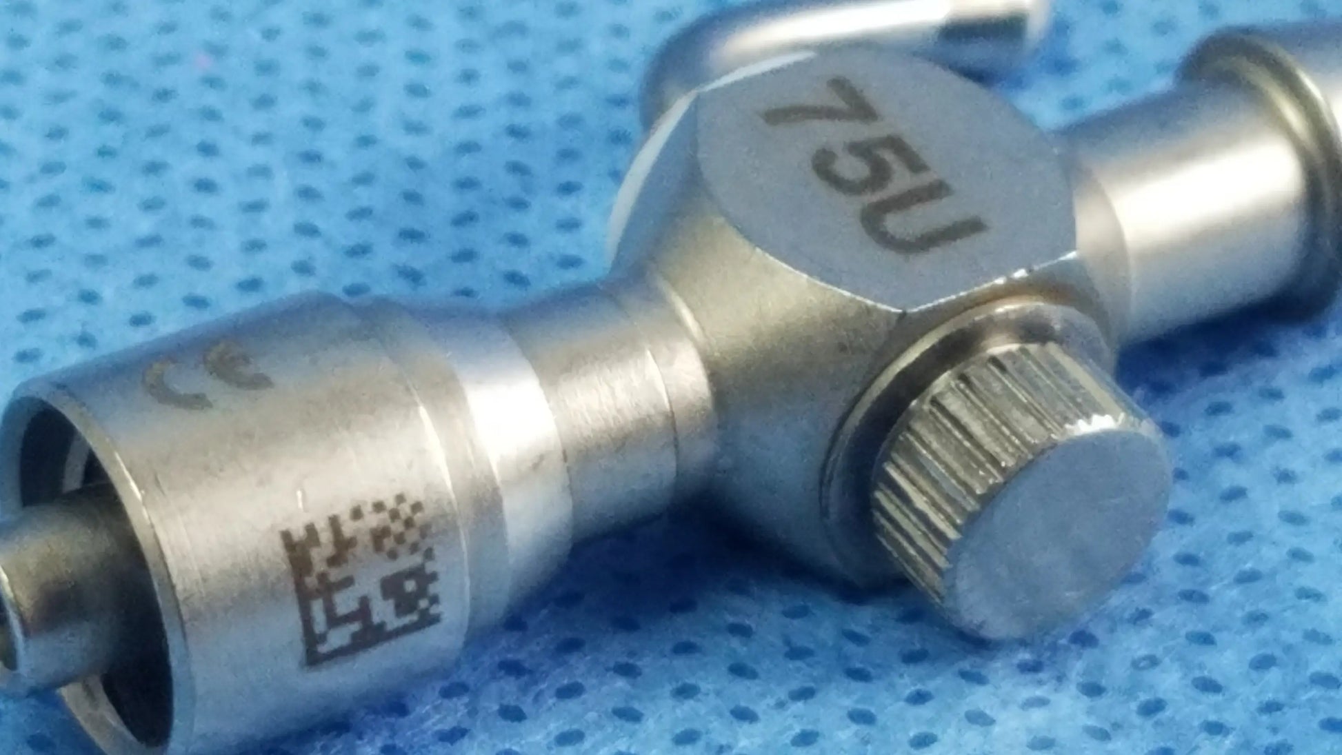Silver metallic 75u universal stopcock with luer lock textured adjustment knob for fluid management in surgery