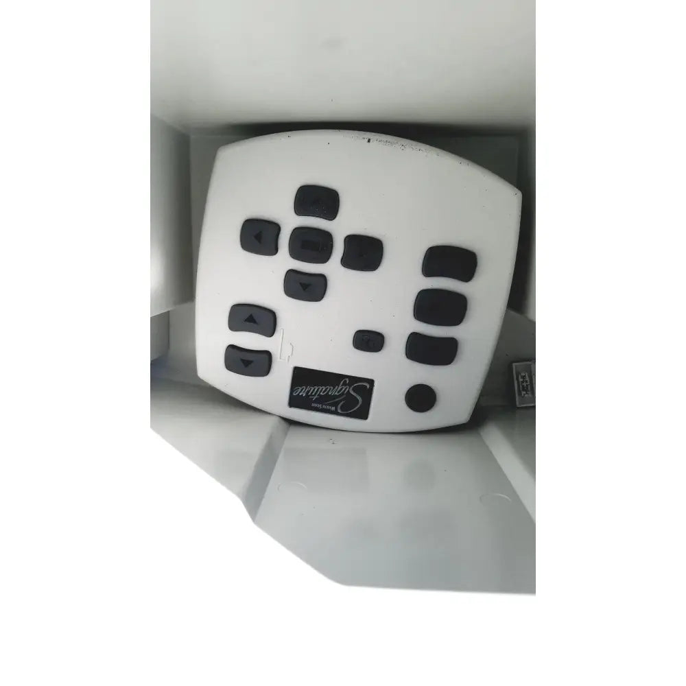 White plastic remote control with black buttons and signature logo for abbott whitestar signature phacoemulsification system