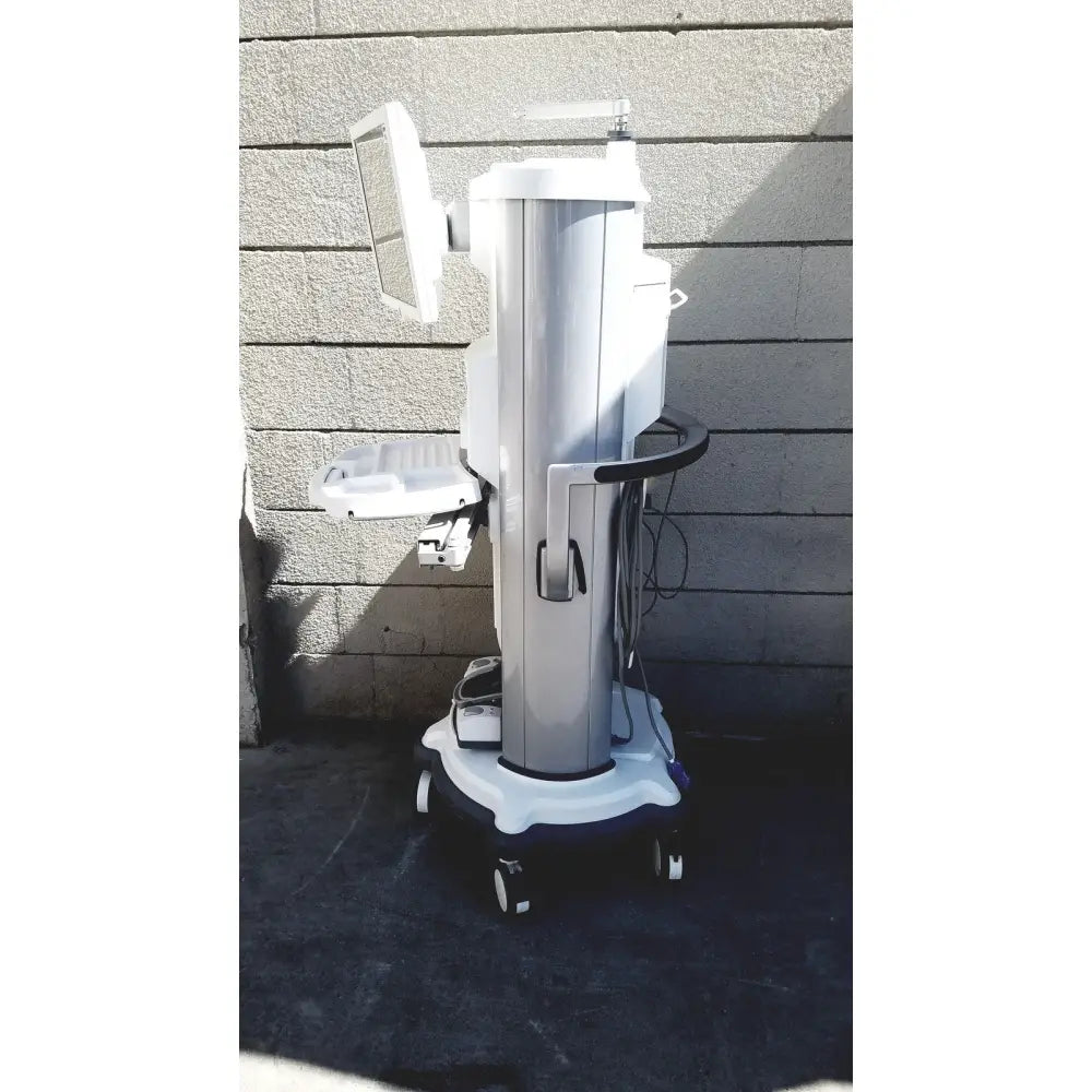 Silver and white abbott whitestar signature phacoemulsification system with monitor, adjustable tray, and wheeled base