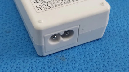 White plastic ac power adapter sed80n2-24 with two round pin sockets and caution label on top surface