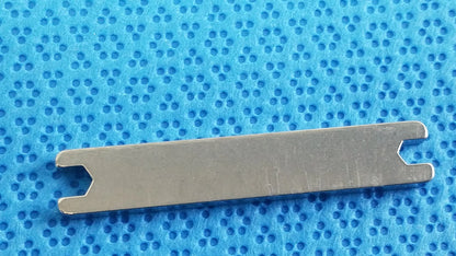 Silver metal medical equipment with rectangular body and notched ends for sterilization tray in dental implant kit