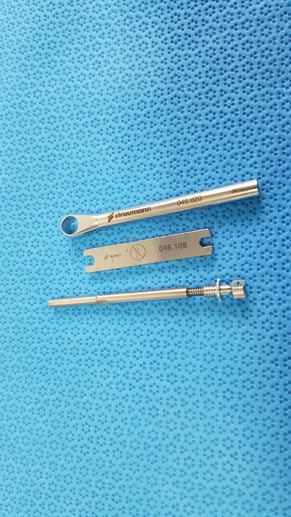 Silver-colored Straumann dental implant screw with threaded shaft and hexagonal head in ACE 765-1001 sterilization tray medical equipment kit