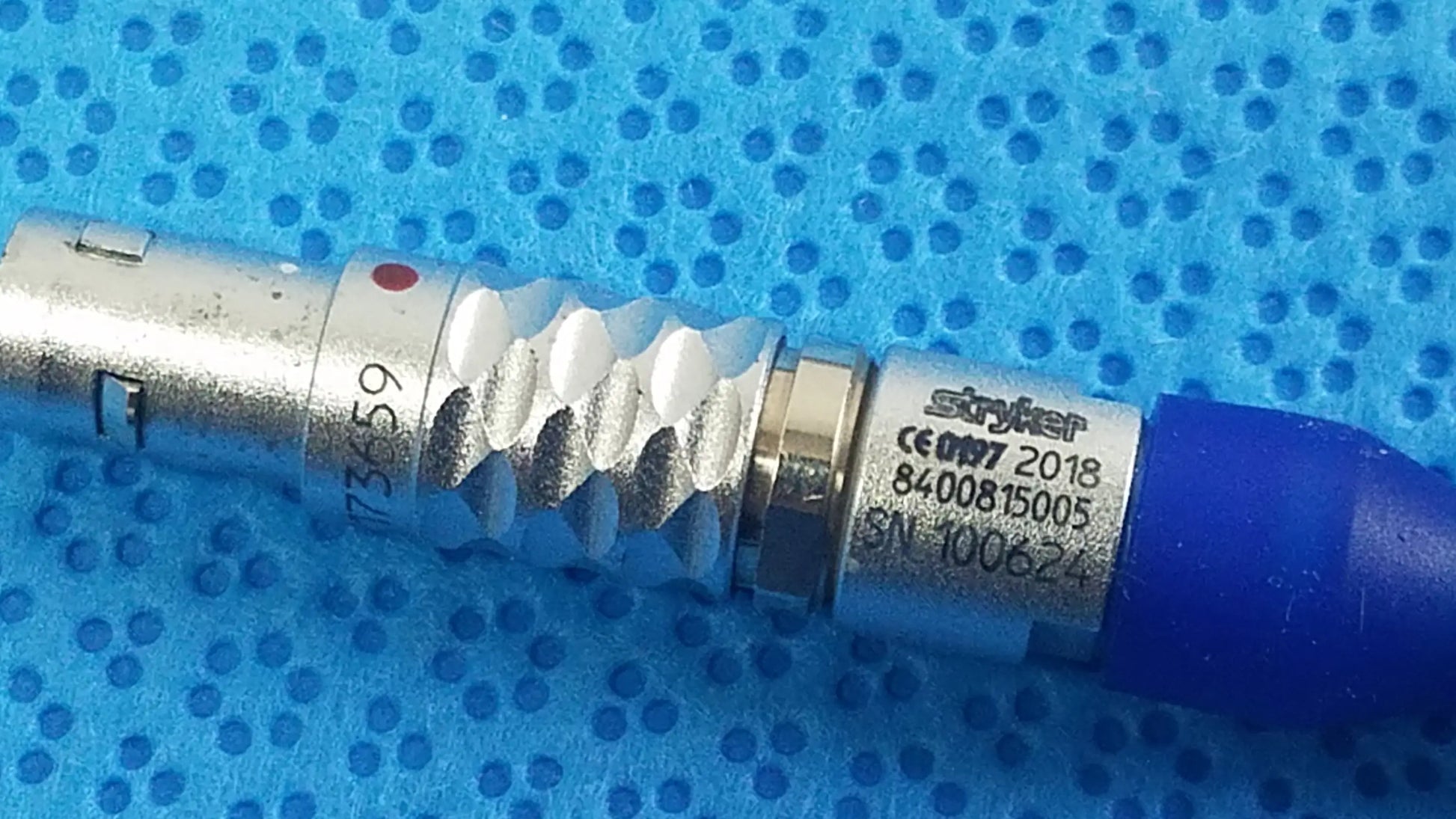 Silver metallic medical connector with blue cap engraved stryker serials for multigen radiofrequency probe sterilization tray
