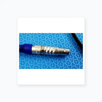 Silver-colored metal connector with blue rubber boot and ridged texture in ace 765-1002 sterilization tray for multigen radiofrequency probe