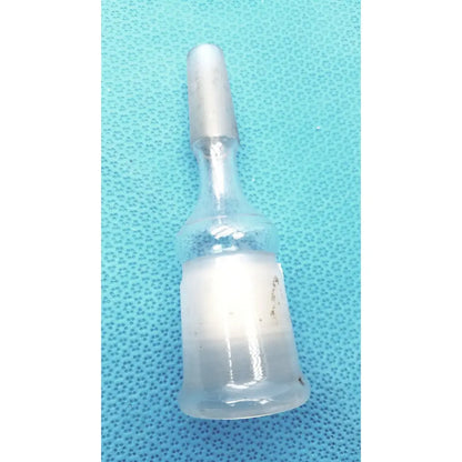 A translucent borosilicate glass ace glass enlarging adapter vial with frosted white cap and cloudy liquid inside