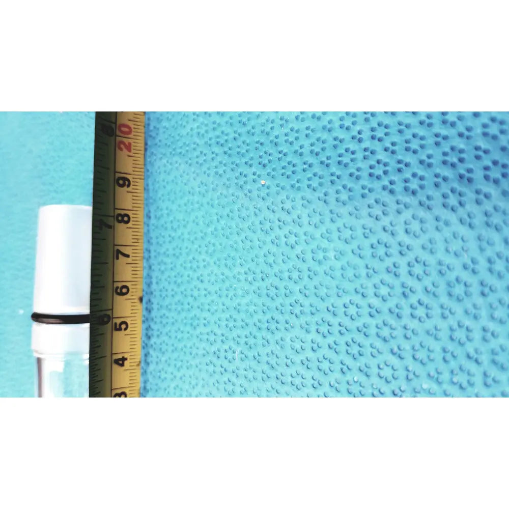 Ace glass thermometer adapter in white glass with black rubber band on neck next to yellow ruler on blue surface