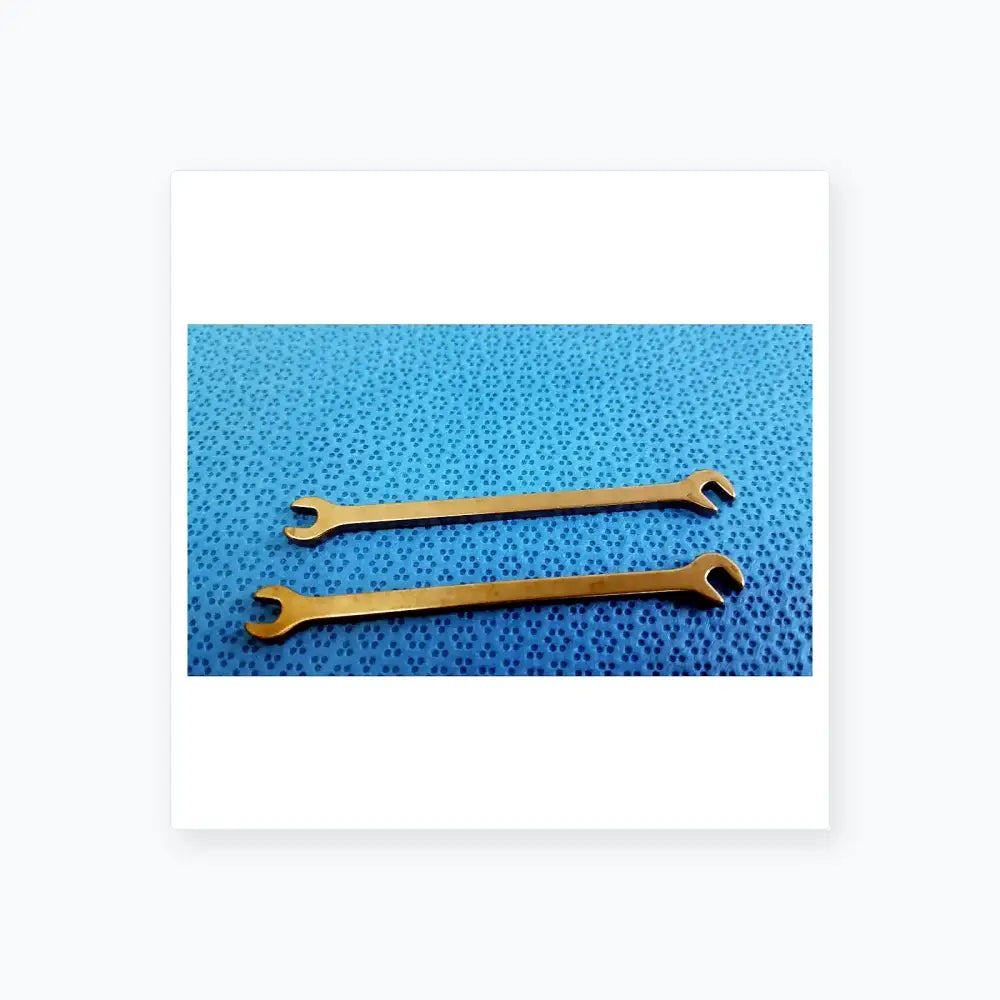 Two polished silver metallic open-end wrenches from ace ophthalmology micro surgery medical equipment on blue surface