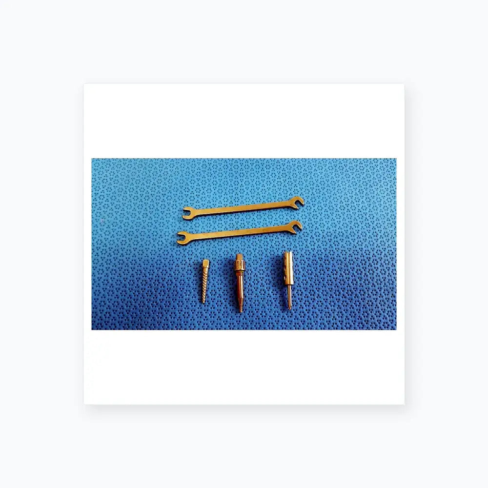 Set of three metallic wrenches and precision screwdriver bits on blue surface for ace ophthalmology micro surgery medical equipment