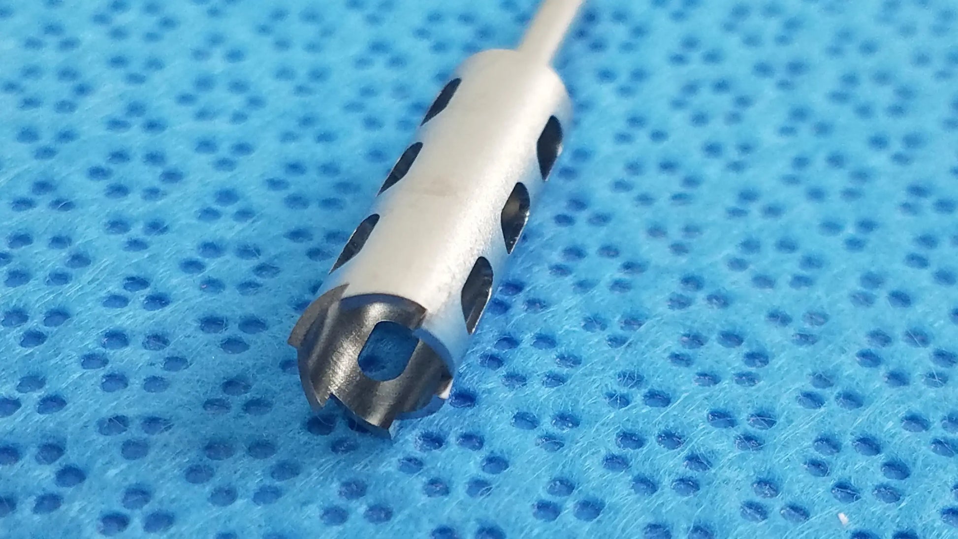 Silver-colored surgical drill bit with circular cutouts and serrated tip from ace ophthalmology micro surgery medical equipment by smiths medical