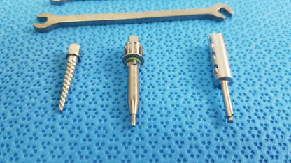 Silver surgical drill bits and wrench on blue textured surface for ace ophthalmology micro surgery medical equipment