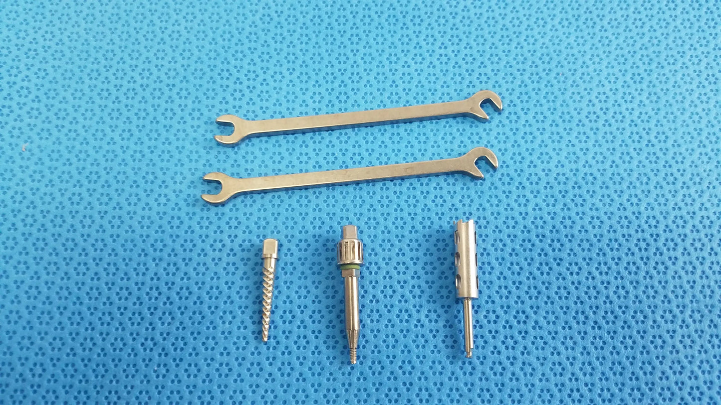 Set of three metallic wrenches and precision screwdriver bits on blue surface for ace ophthalmology micro surgery medical equipment