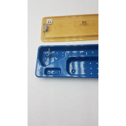 Blue and yellow plastic acmi mra-gt slimline sterilization and storage tray with perforated surfaces and molded compartments