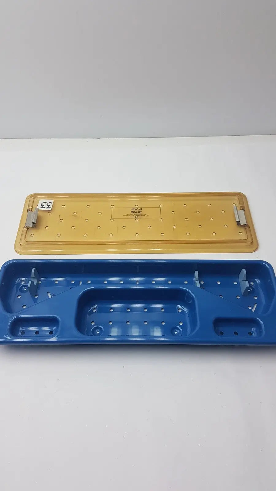 Blue and yellow plastic acmi mra-gt slimline sterilization and storage tray designed for surgical instrument organization