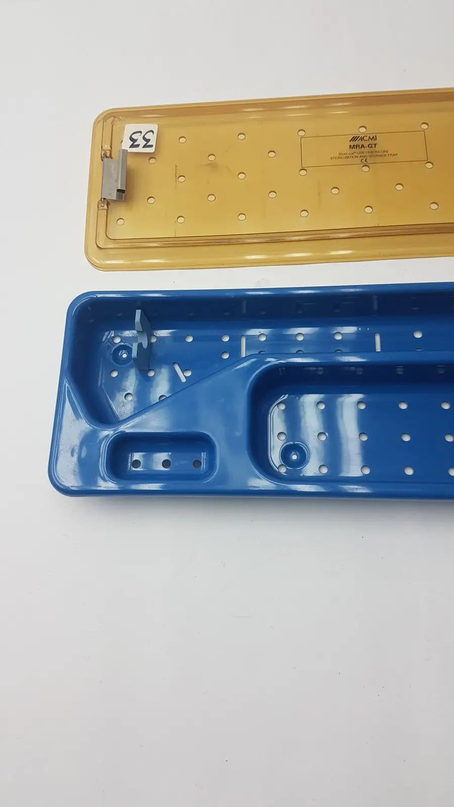 Blue and yellow plastic acmi mra-gt slimline sterilization and storage tray with perforated surfaces and molded compartments