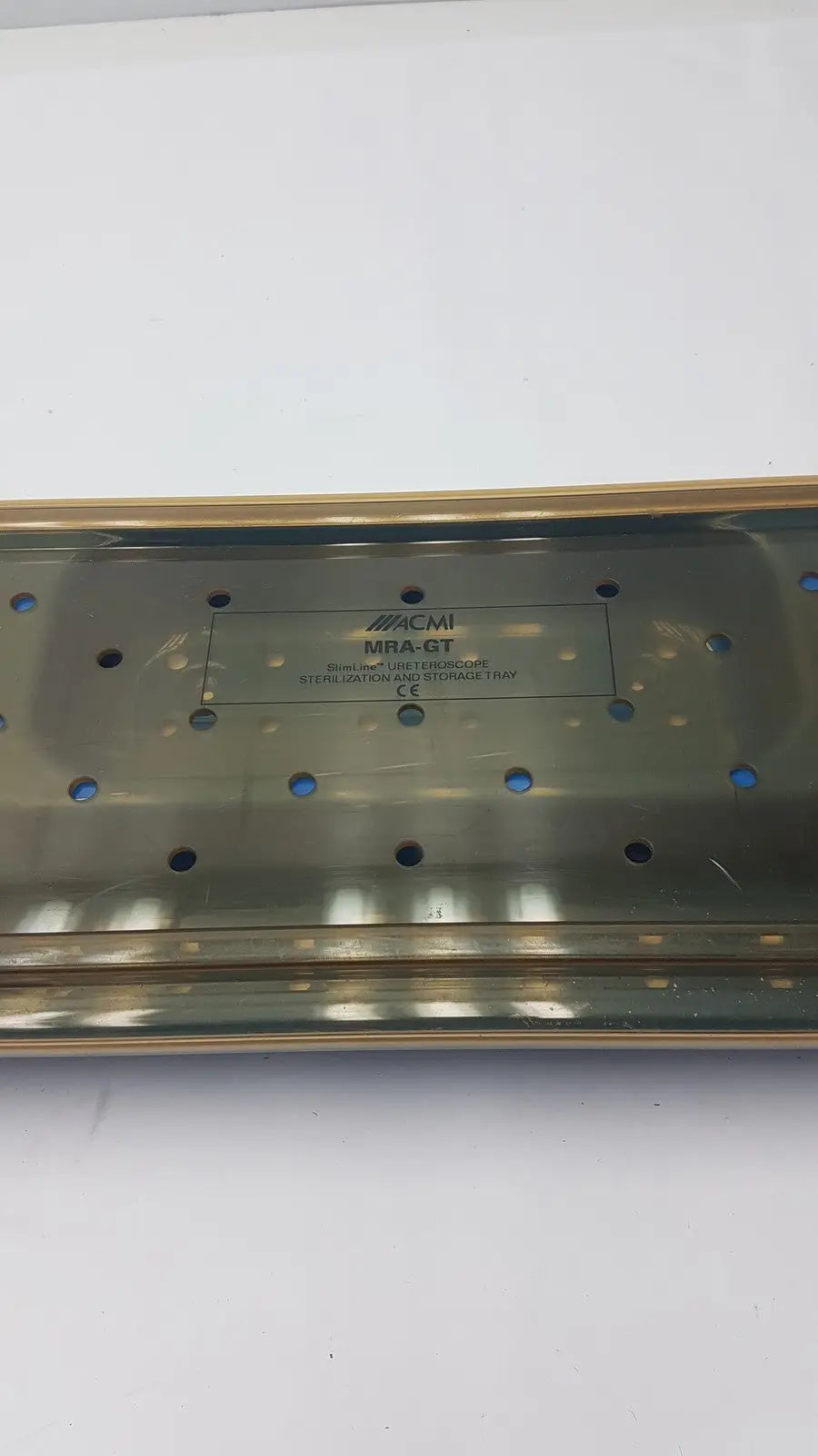 A metallic brushed acmi mra-gt slimline sterilization storage tray with rectangular shape and circular ventilation holes