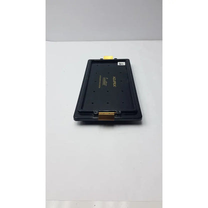 Black plastic acufex suretac instrument tray with gold metal clasp and yellow tab empty suretac instrument system tray