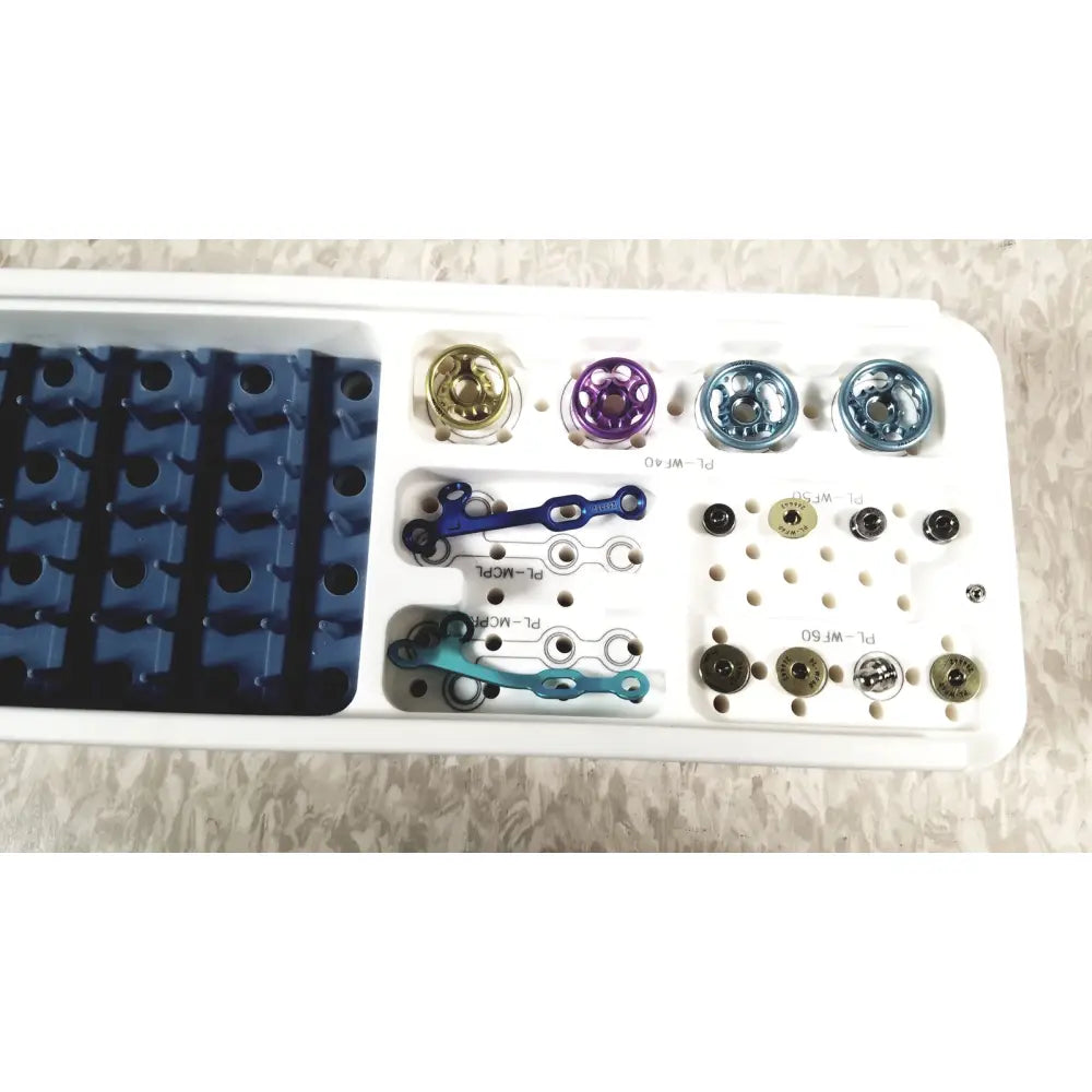 White plastic tray holding colorful metallic orthopedic implants for acumed modular hand system missing piece