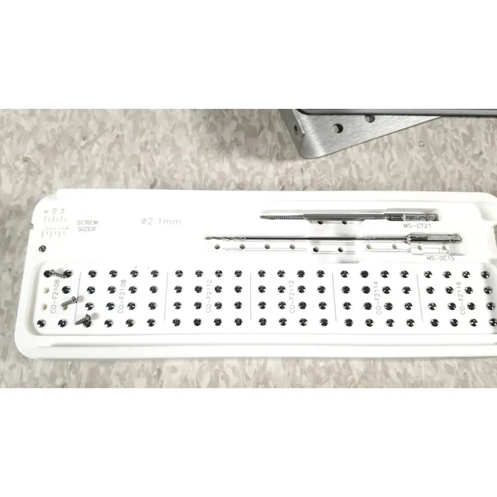 White plastic tray holding metallic surgical screws and drill bits in acumed modular hand system set missing piece