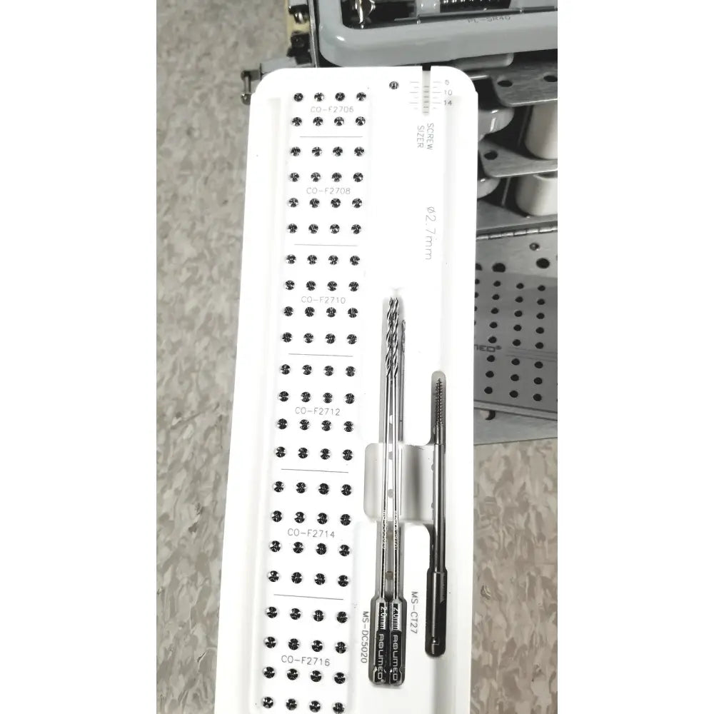 White plastic tray holding multiple metal surgical instruments for acumed modular hand system missing piece set