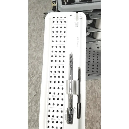 White plastic tray holding multiple metal surgical instruments for acumed modular hand system missing piece set