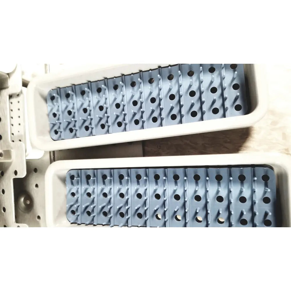 Gray plastic ice cube trays with raised ridges and circular indentations for acumed modular hand system missing piece