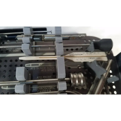 Gray plastic-handled surgical instruments with metallic shafts including at2 screw sizer and arthroscopic cannula for headless compression screw system