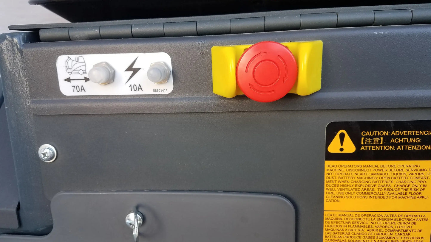 Red emergency stop button with yellow guards on gray industrial Advance ES4000 ride on carpet cleaner extractor