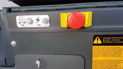 Red emergency stop button with yellow guards on gray industrial Advance ES4000 ride on carpet cleaner extractor