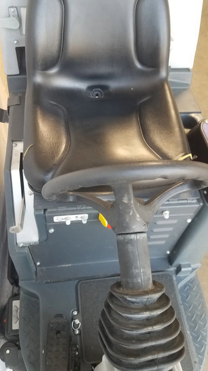 Black leather-like seat with integrated headrest and steering wheel on advance ride on carpet cleaner extractor utility vehicle