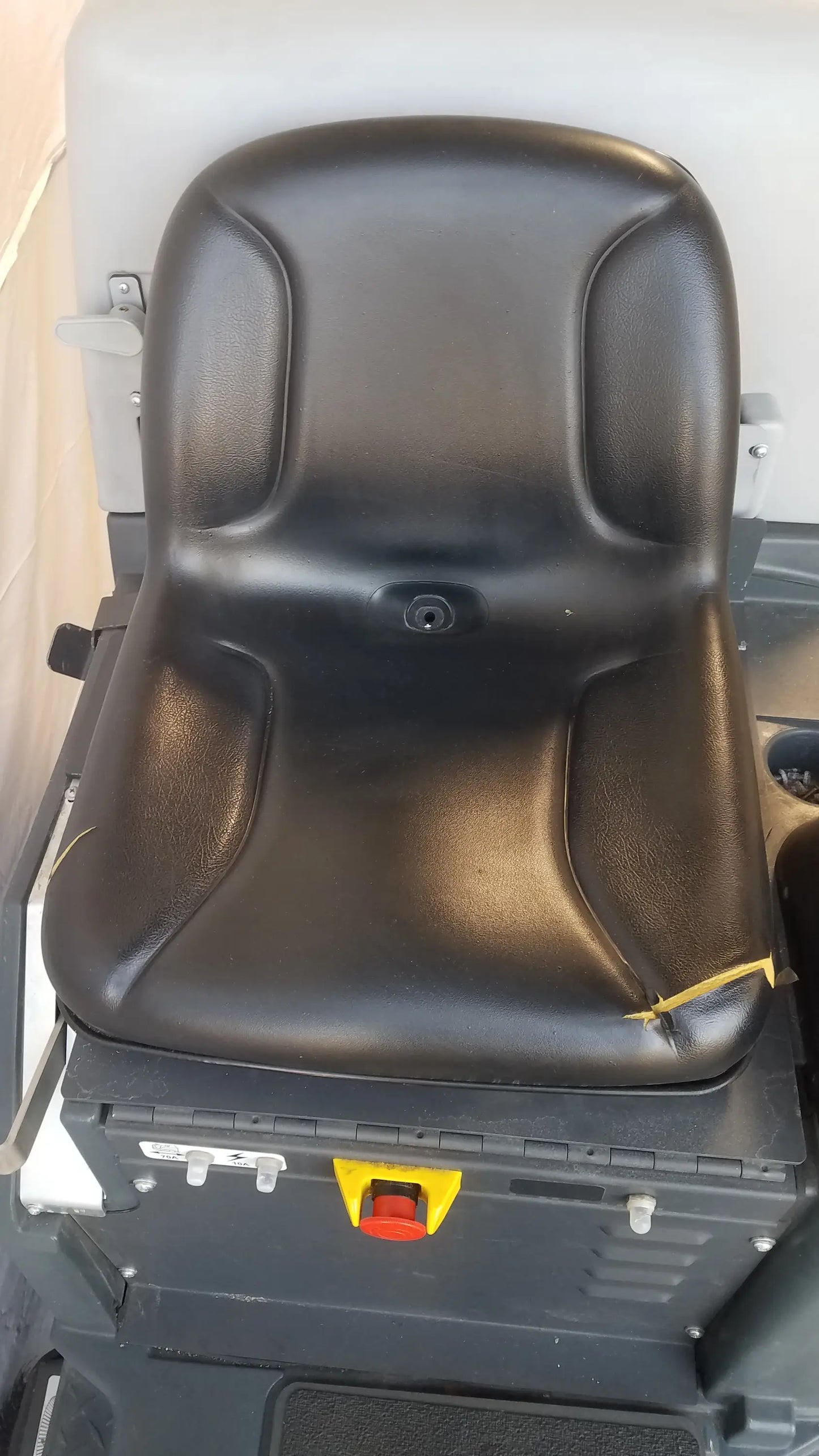 Black leather seat with molded contours and central keyhole on advance ride on carpet cleaner extractor wet dry vacuum