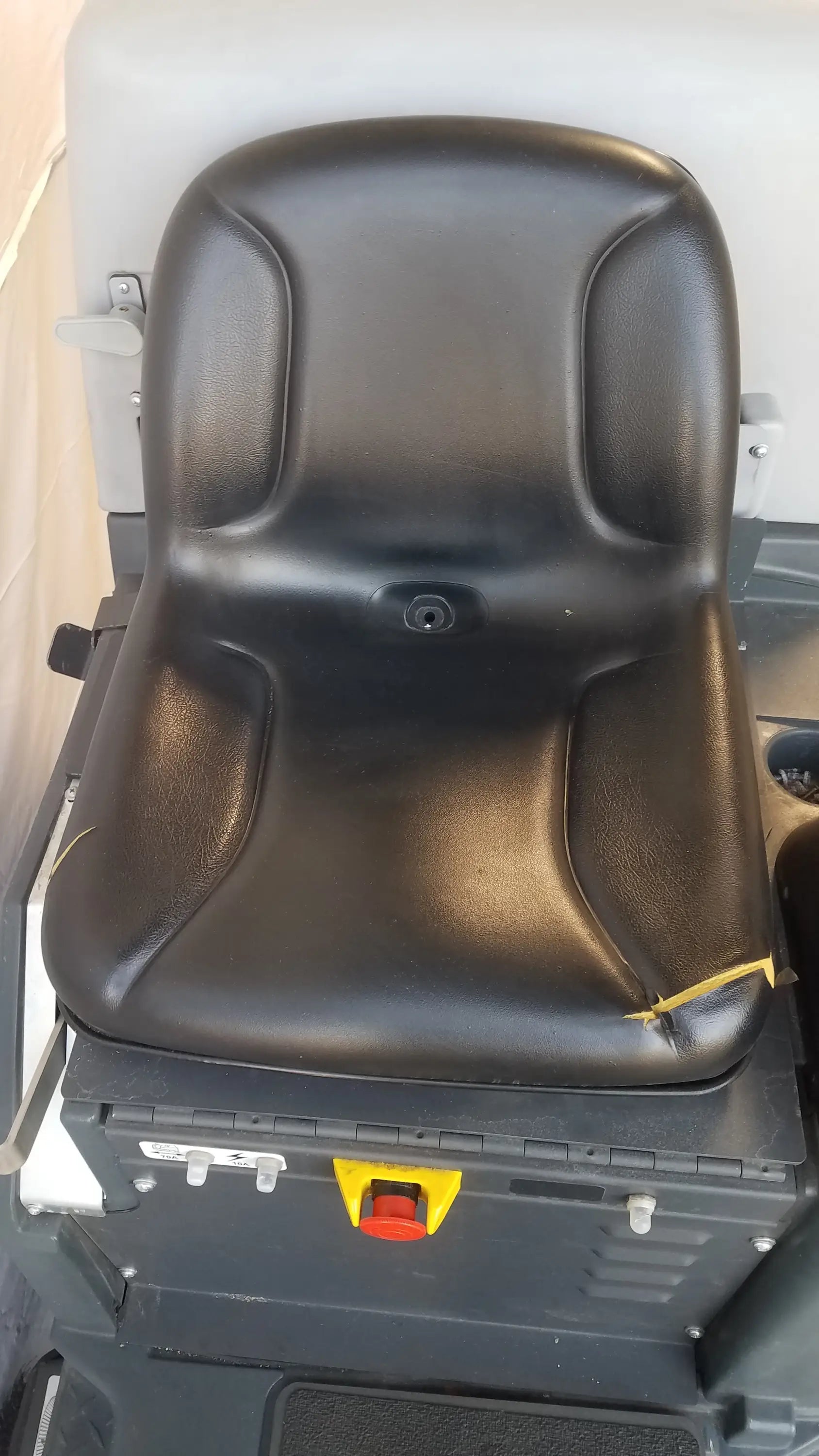Black leather seat with molded contours and central keyhole on advance ride on carpet cleaner extractor wet dry vacuum