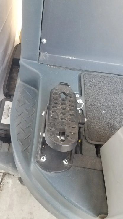 Black rubber foot pedal with textured surface and metal bracket on advance ride on carpet cleaner extractor wet dry vacuum