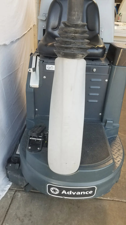 Gray advance ride on carpet cleaner extractor with black seat and white cylindrical scrubber attachment for industrial use