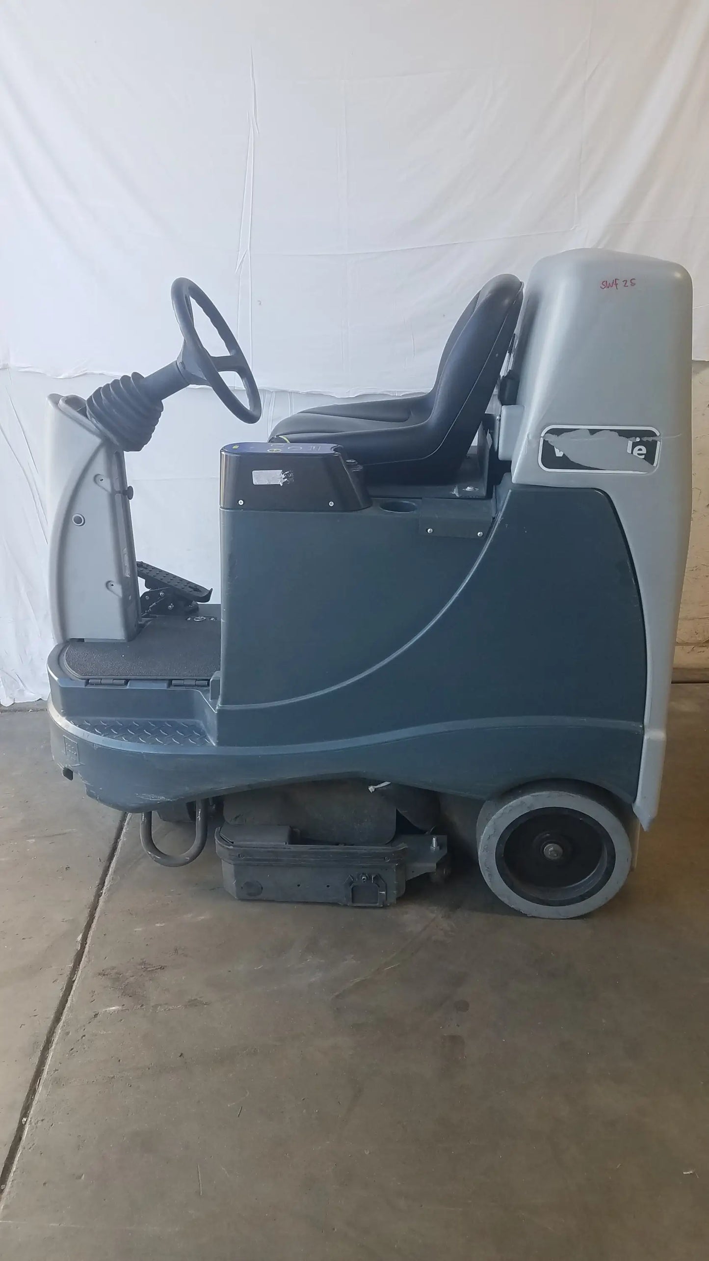Advance ride on carpet cleaner extractor in gray and black with steering wheel and operator seat for industrial cleaning